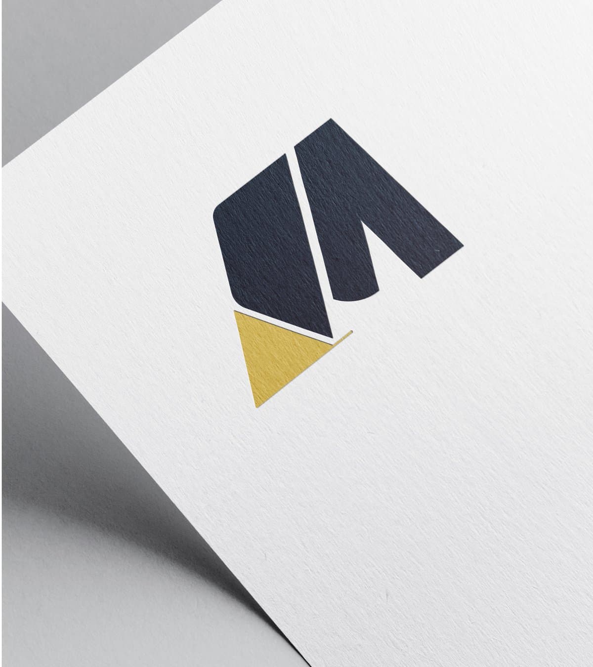 Gold foil M mark on textured paper